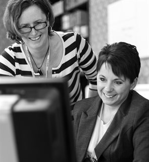 Two workers looking at a computer