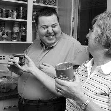 Man in his kitchen smiling at his personal assistant