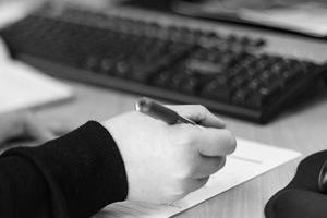 lady at computer with pen and paper