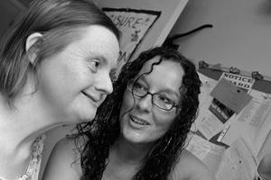 Care worker and individual who needs care and support looking at a computer screen
