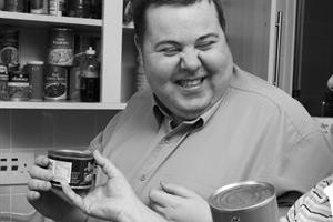 Man in his kitchen smiling at his personal assistant